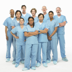 Group portrait of doctors in scrubs on white background